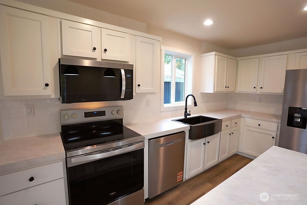 50 East Lookout Court Grapeview, WA 98546 - Photo 15 of 34 a kitchen with stainless steel appliances white cabinets and a stove a sink