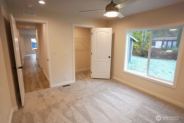 an empty room with fan and entrance