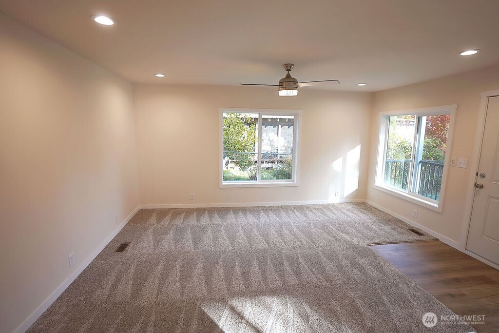 50 East Lookout Court Grapeview, WA 98546 - Photo 25 of 34 an empty room with wooden floor a ceiling fan and windows