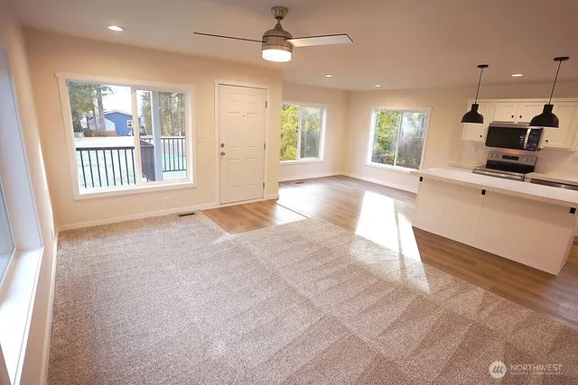 a view of a kitchen with a sink and dishwasher a fireplace with wooden floor