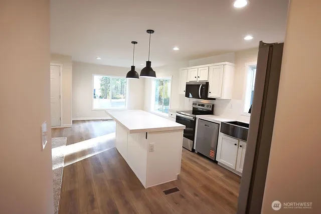 a kitchen with a sink a microwave a stove and refrigerator