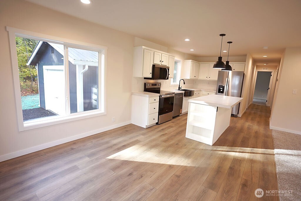 50 East Lookout Court Grapeview, WA 98546 - Photo 9 of 34 a view of a kitchen with a sink wooden floor and a living room