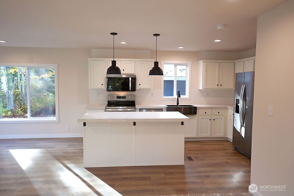 50 East Lookout Court Grapeview, WA 98546 - Photo 10 of 34 a kitchen with stainless steel appliances granite countertop a sink a stove and a refrigerator