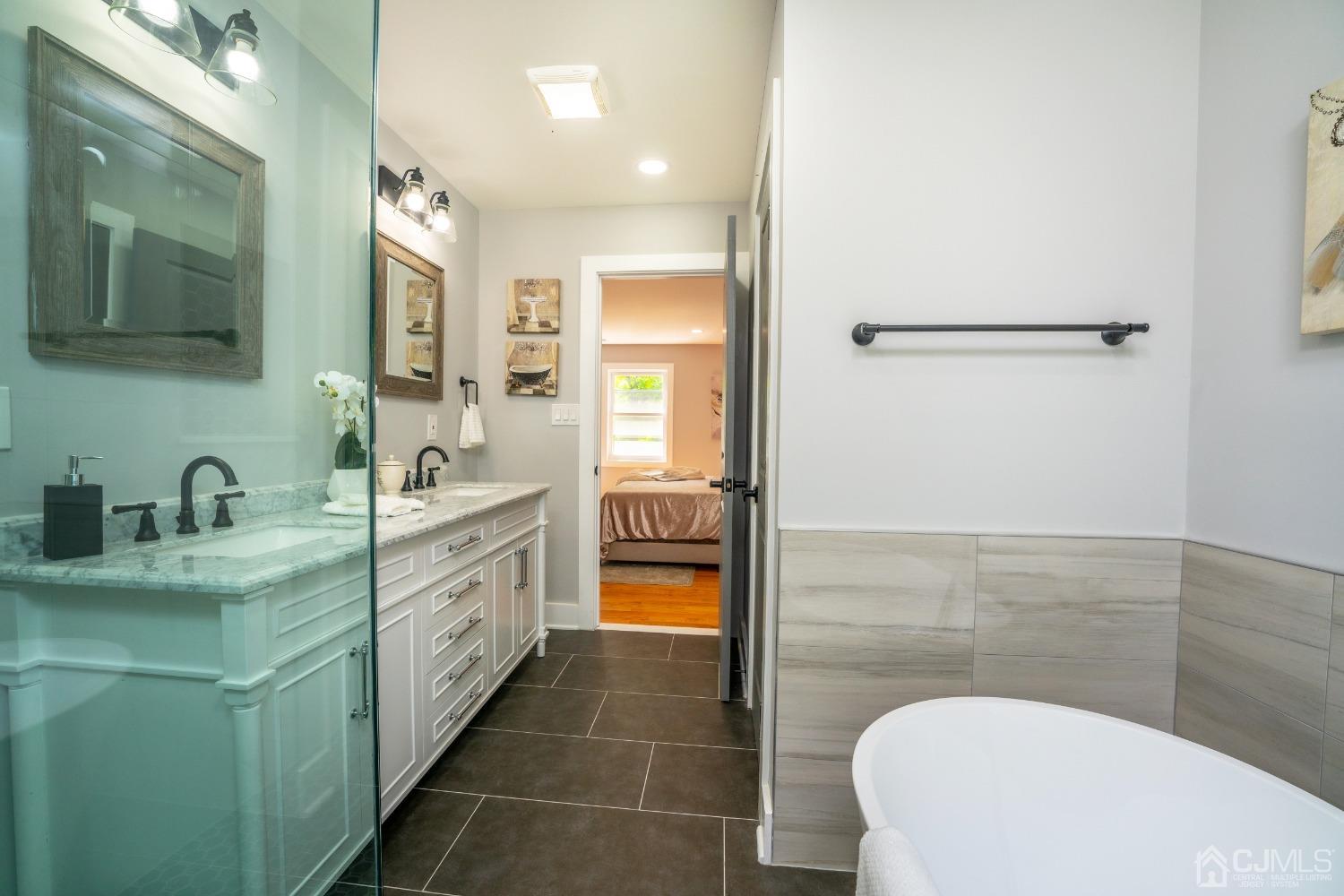 45 East Cliff Road Colonia, NJ 07067 - Photo 19 of 31 a bathroom with a granite countertop sink a toilet a mirror and shower