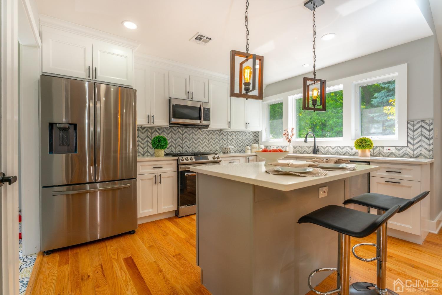 45 East Cliff Road Colonia, NJ 07067 - Photo 7 of 31 a kitchen with stainless steel appliances a stove a sink dishwasher a refrigerator with a dining table and chairs