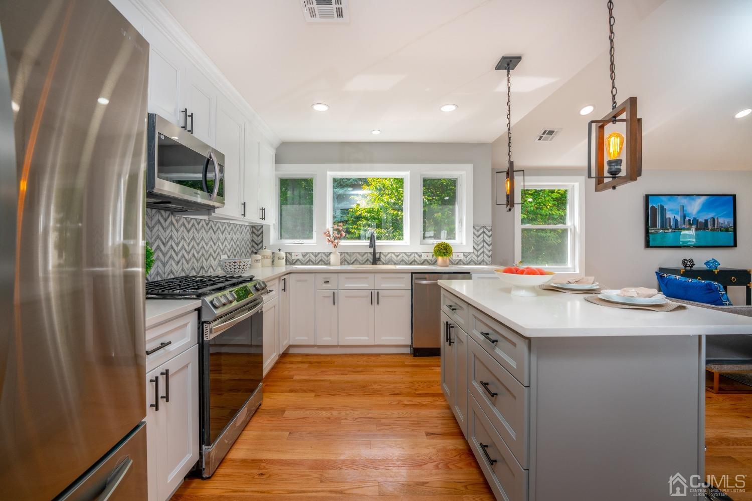 45 East Cliff Road Colonia, NJ 07067 - Photo 8 of 31 a kitchen with stainless steel appliances granite countertop a sink and a stove