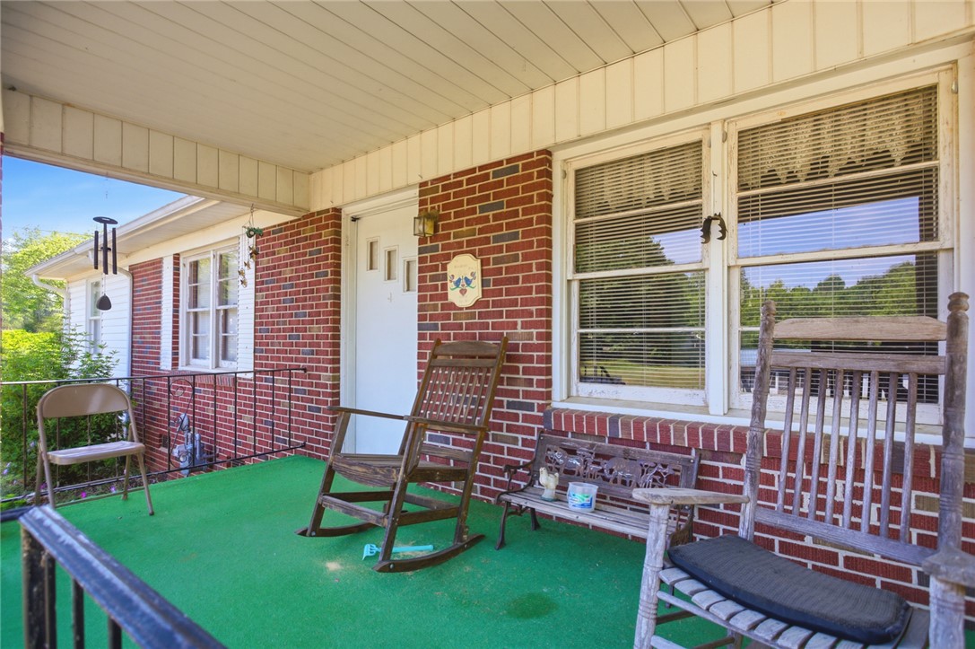 282 West Bennett Road Westminster, SC 29693 - Photo 30 of 42 This inviting porch offers a warm welcome with its classic brick facade and serene outdoor setting.
