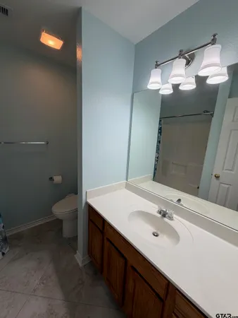 a bathroom with a sink vanity and a toilet