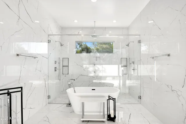 a bathroom with a bathtub a mirror a shower and vanity