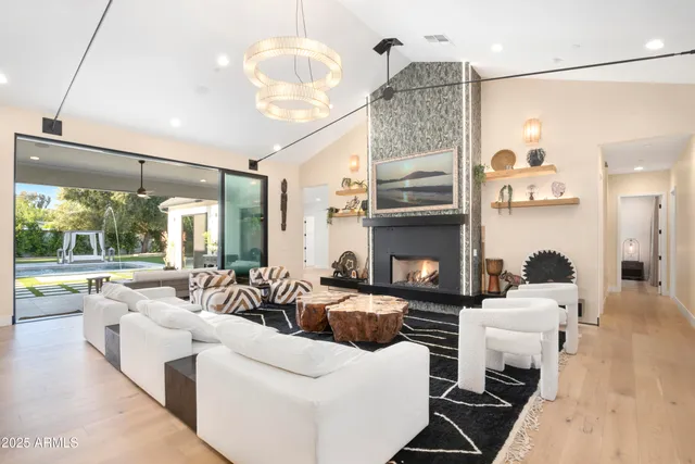 a living room with furniture fireplace and a large window
