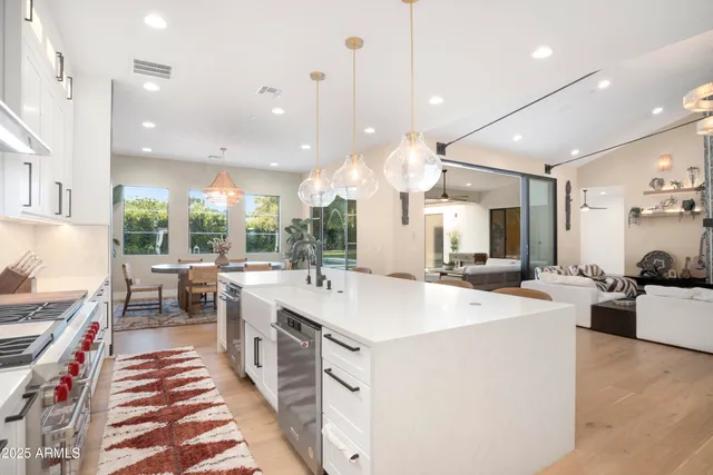 a kitchen with a sink a refrigerator and chairs