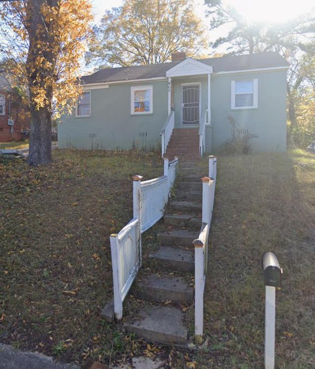 a view of a house with backyard and a tree