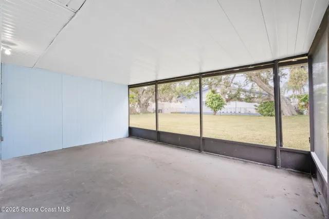 a front view of a house with a large tree