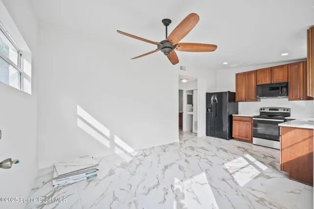 a large kitchen with stainless steel appliances kitchen island granite countertop a refrigerator and a sink