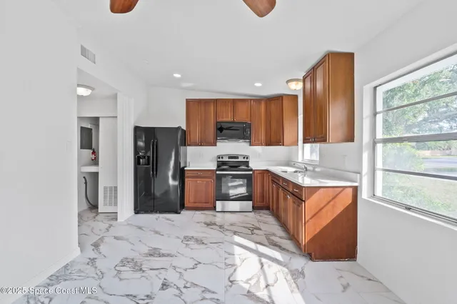 a kitchen with stainless steel appliances granite countertop a refrigerator stove top oven and sink