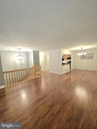 a view of an empty room with wooden floor and a floor to ceiling window