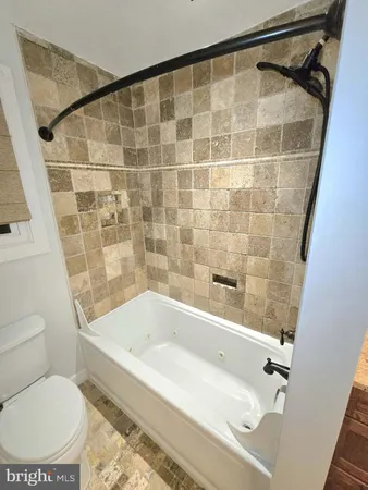 a bathroom with a bathtub and a toilet