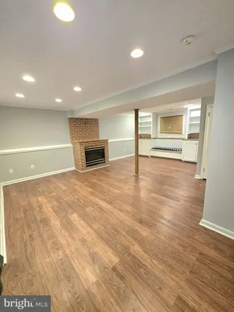 a view of empty room with wooden floor and window