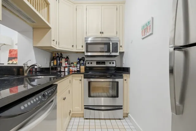 a kitchen with stainless steel appliances granite countertop a stove a refrigerator and a microwave