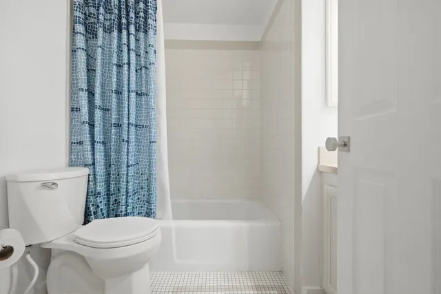 a white toilet sitting next to a bath tub