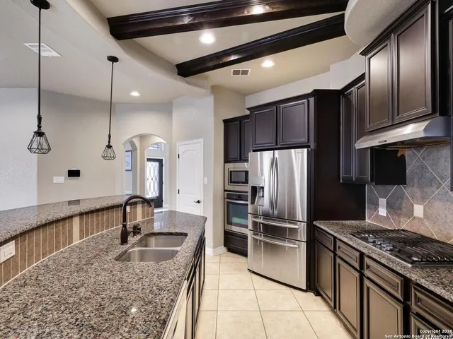 a kitchen with stainless steel appliances granite countertop a sink stove and refrigerator