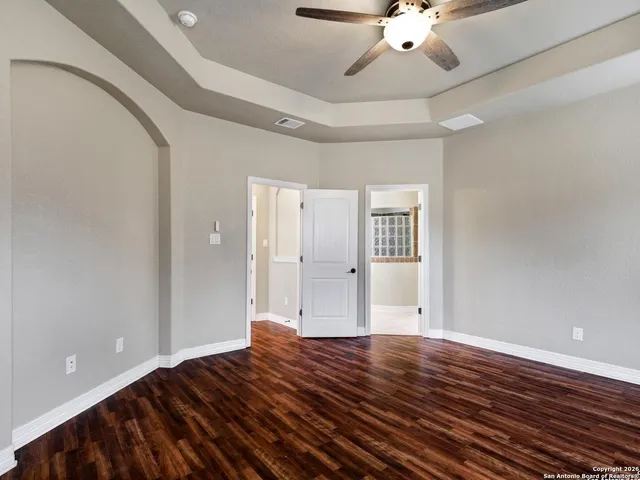 a view of a room with wooden floor and a ceiling fan