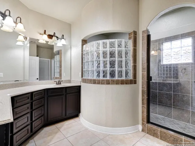 a bathroom with a double vanity sink mirror and bathtub