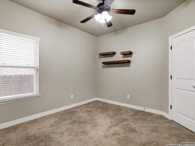 a view of a livingroom with a ceiling fan and window