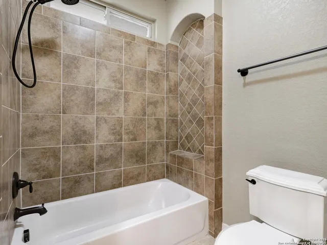 a white bath tub sitting next to a white toilet and a shower