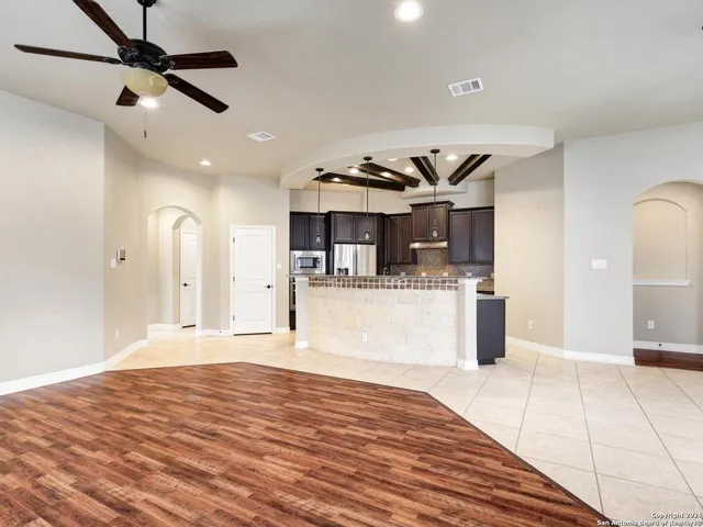 a view of a kitchen with kitchen island wooden floor center island and stainless steel appliances