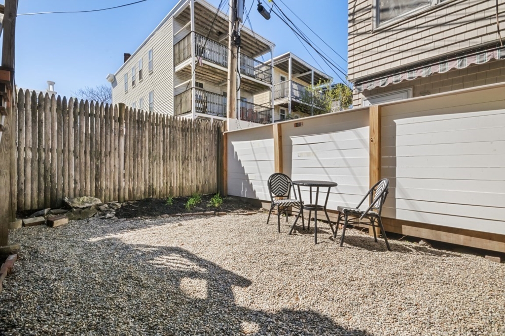 508 East 3rd Street, Unit 2 Boston, MA 02127 - Photo 16 of 17 a backyard of a house with chairs and wooden fence