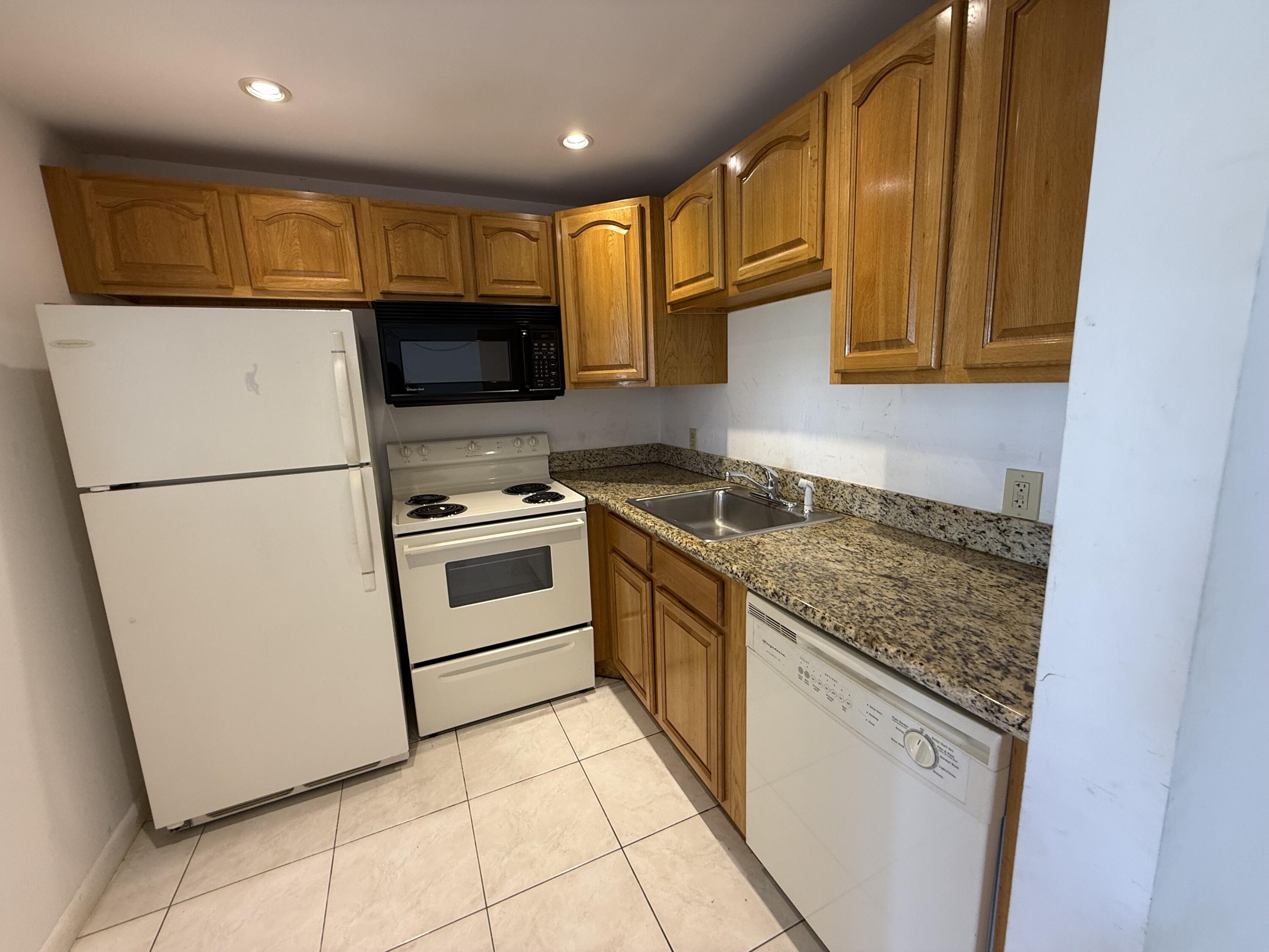 13 Dorset A Boca Raton, FL 33434 - Photo 11 of 69 a kitchen with granite countertop a sink stainless steel appliances and cabinets