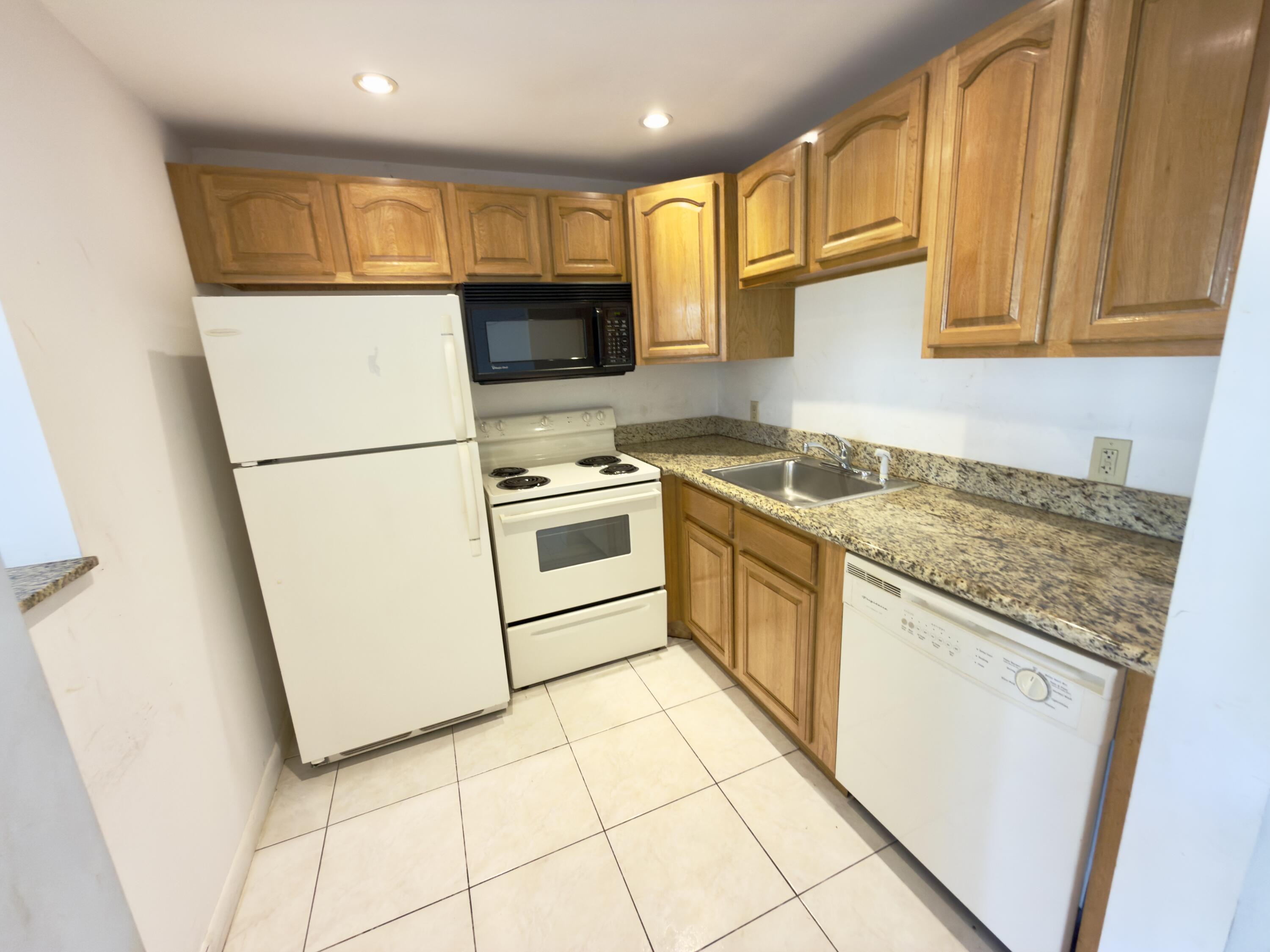 13 Dorset A Boca Raton, FL 33434 - Photo 12 of 69 a kitchen with stainless steel appliances granite countertop a stove a sink and a refrigerator