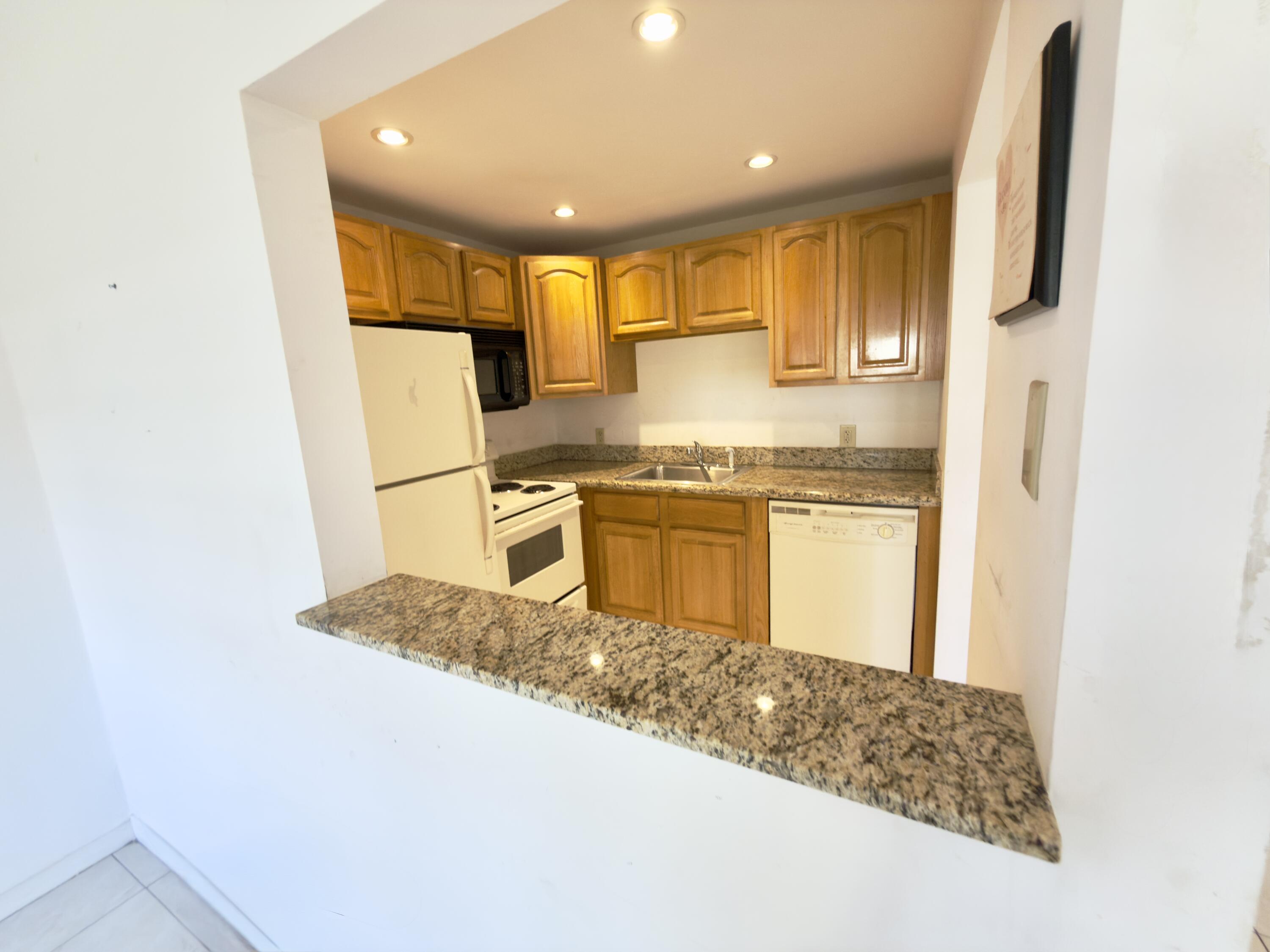 13 Dorset A Boca Raton, FL 33434 - Photo 13 of 69 a kitchen with stainless steel appliances granite countertop a sink a stove and a refrigerator