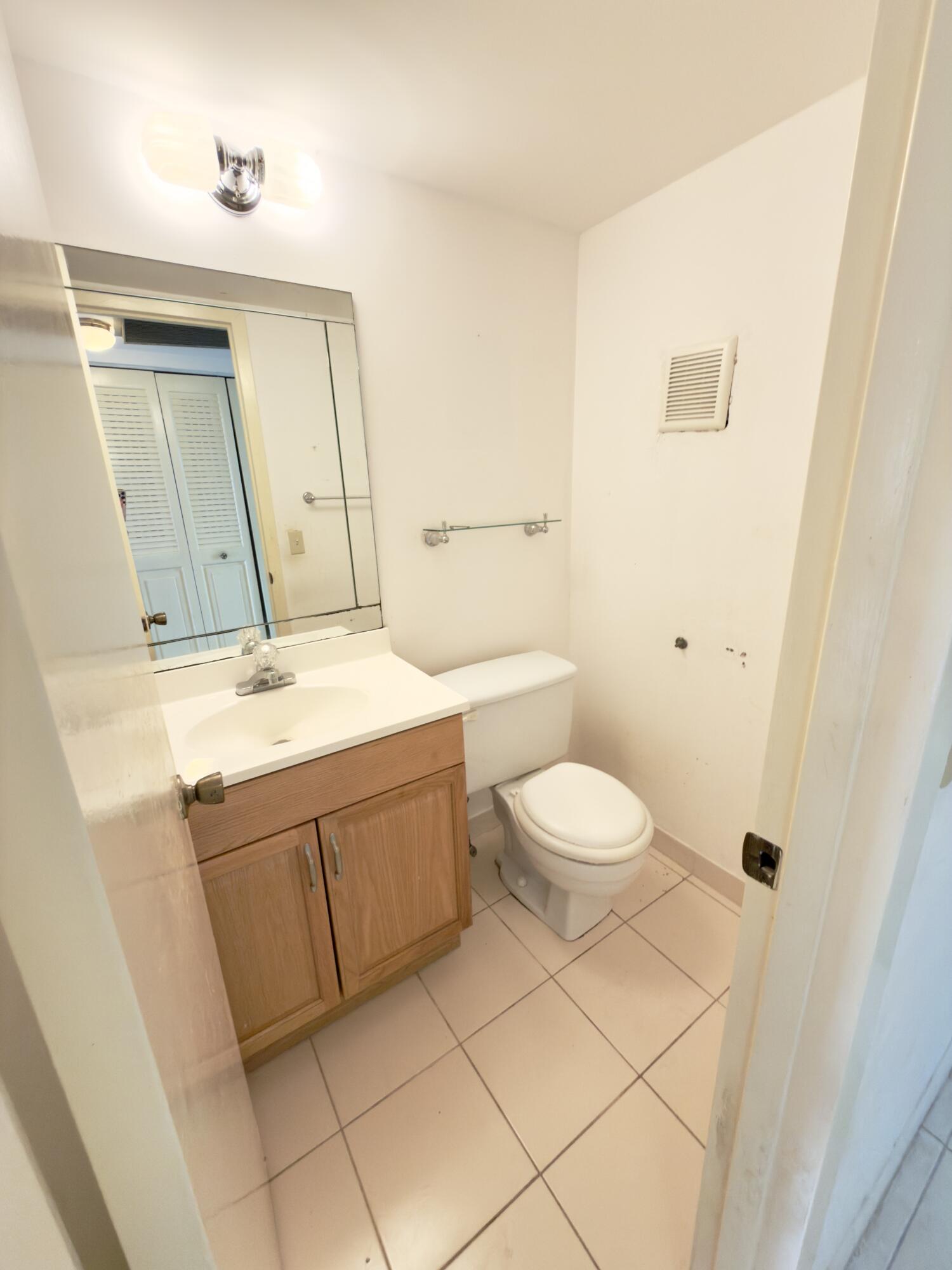 13 Dorset A Boca Raton, FL 33434 - Photo 26 of 69 a bathroom with a sink a toilet and mirror