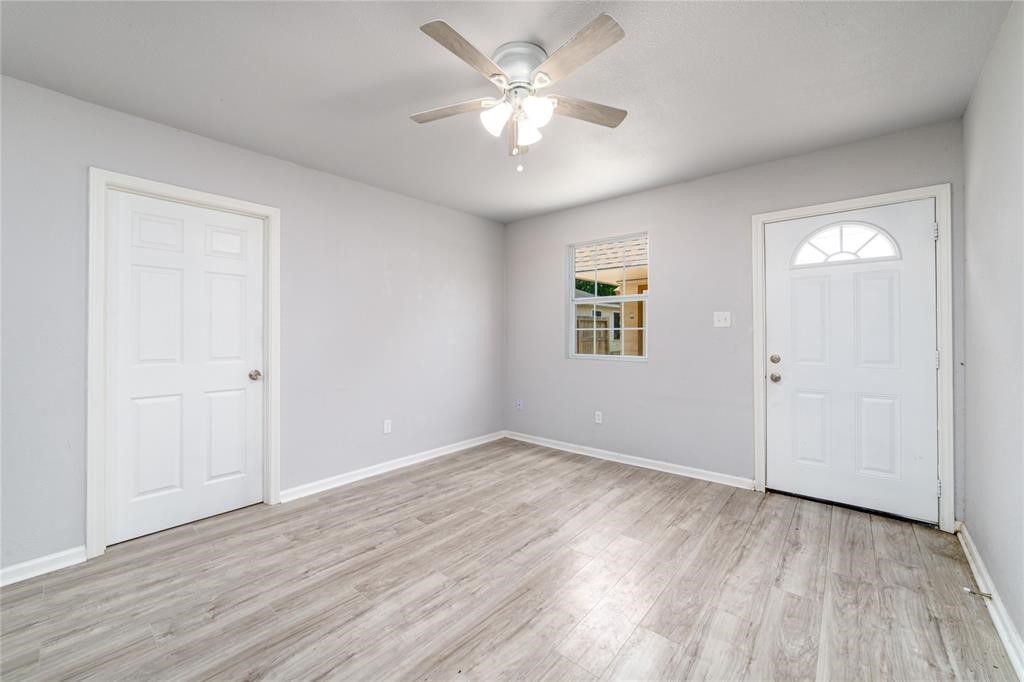 1309 Jefferson Street, Unit C Baytown, TX 77520 - Photo 5 of 9 an empty room with wooden floor and a ceiling fan