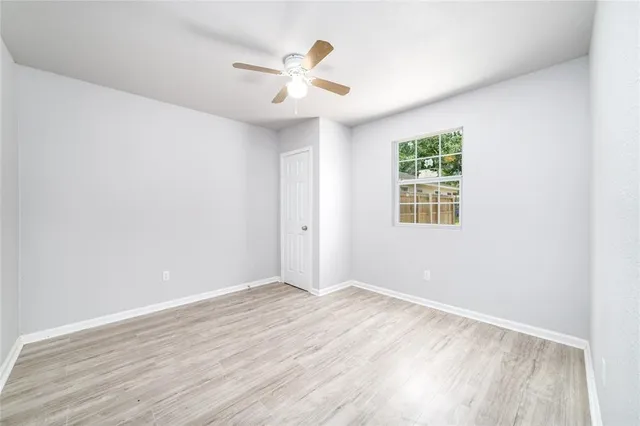 an empty room with wooden floor and chandelier