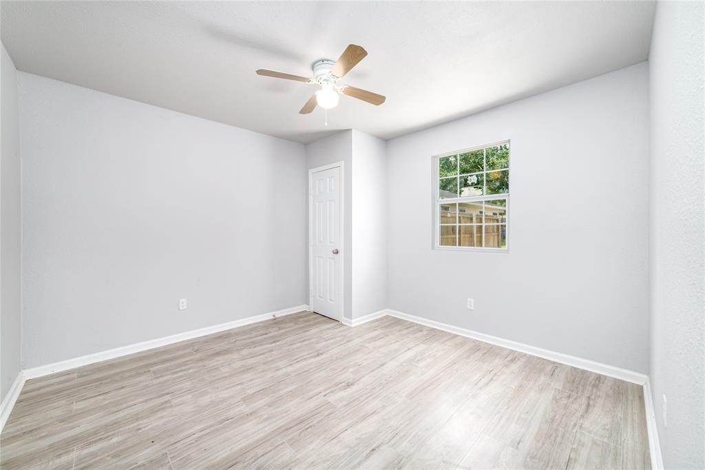 1309 Jefferson Street, Unit C Baytown, TX 77520 - Photo 8 of 9 an empty room with wooden floor and chandelier