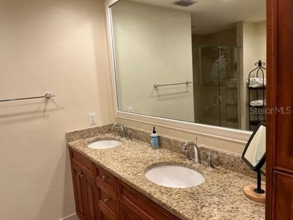 a bathroom with a granite countertop sink and a mirror