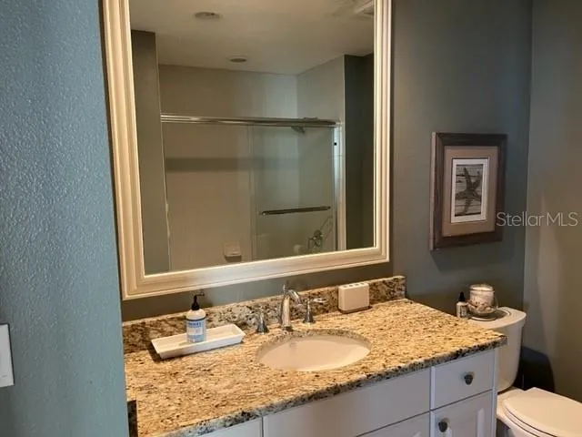 a bathroom with a granite countertop sink and a mirror