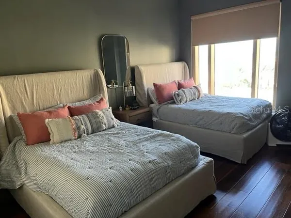 a bedroom with two beds and a chair