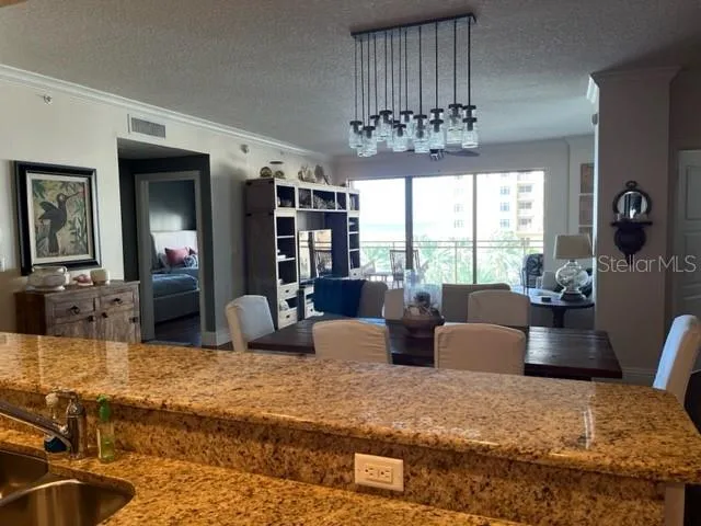 a living room with furniture chandelier and large window