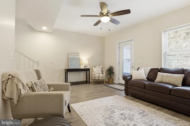 a living room with furniture and a wooden floor