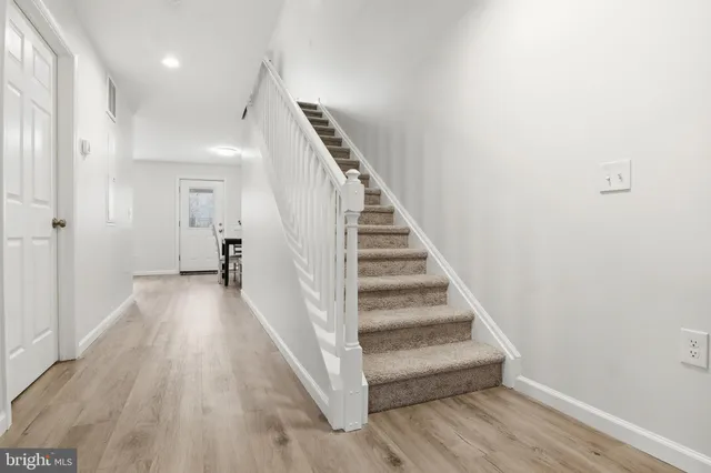 a view of a hallway with wooden floor and stairs