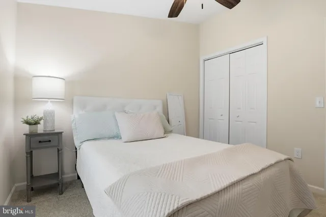 a bedroom with a bed and a potted plant on the dresser