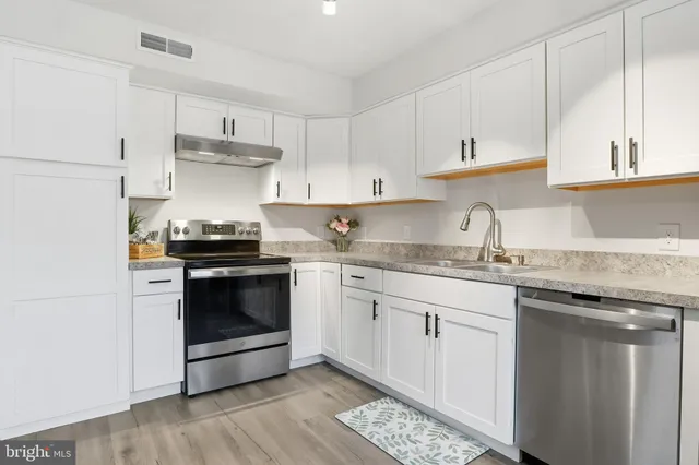 a kitchen with granite countertop white cabinets and appliances