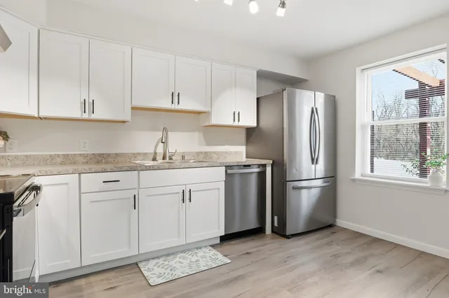 a kitchen with granite countertop cabinets appliances and a window