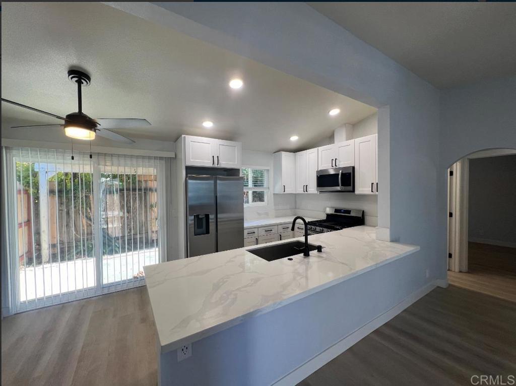 a kitchen with stainless steel appliances kitchen island granite countertop a refrigerator and microwave
