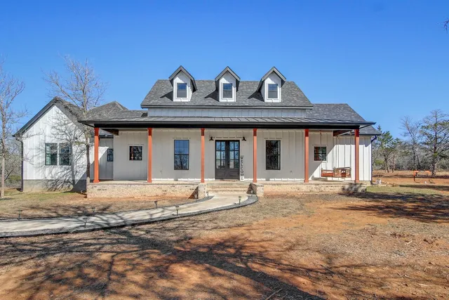 a front view of a house with a garden and yard