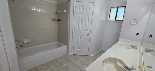 a bathroom with a tub a sink and a shower